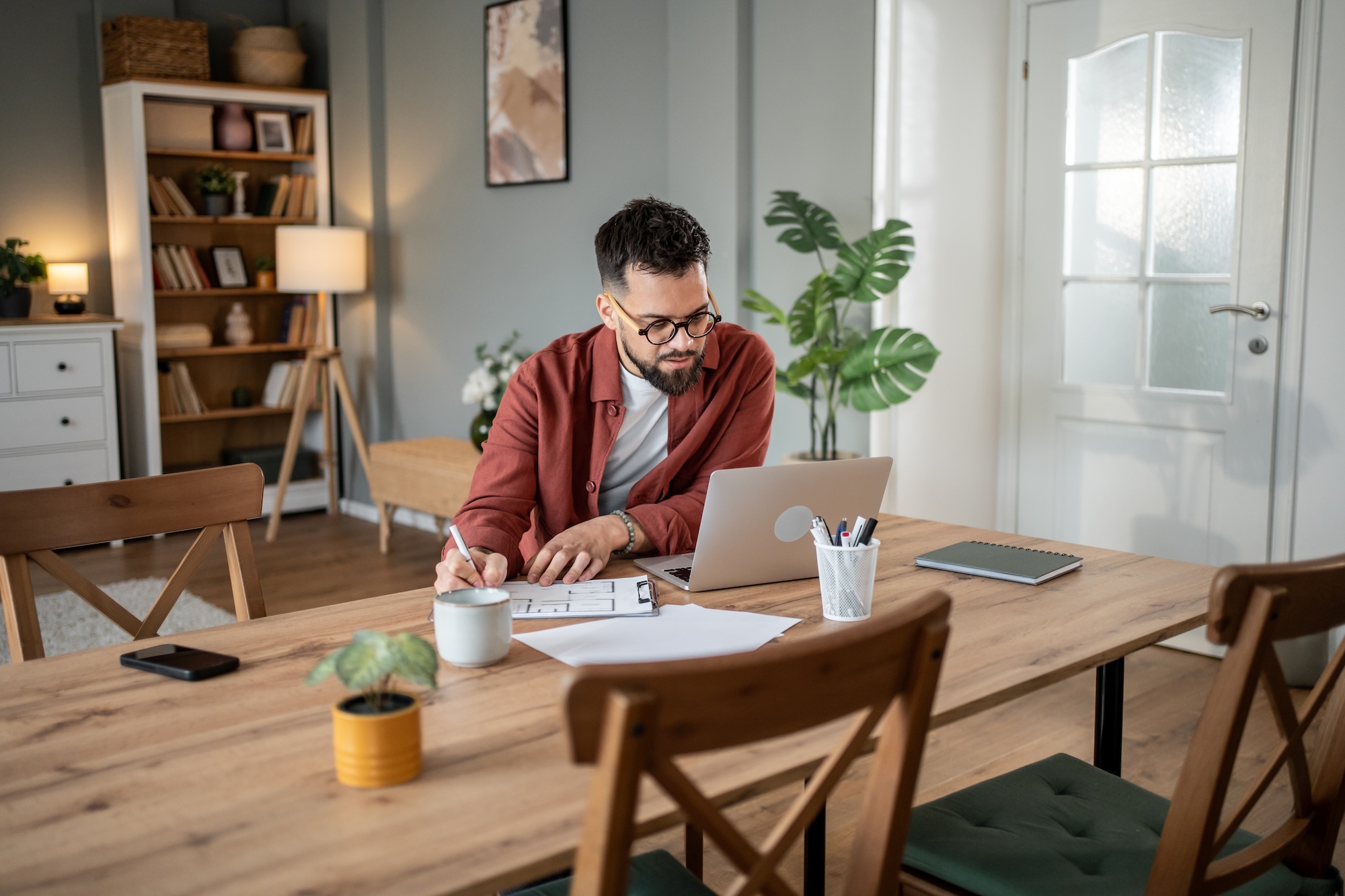 Focused Entrepreneur Working Remotely From Home Office Taking Notes